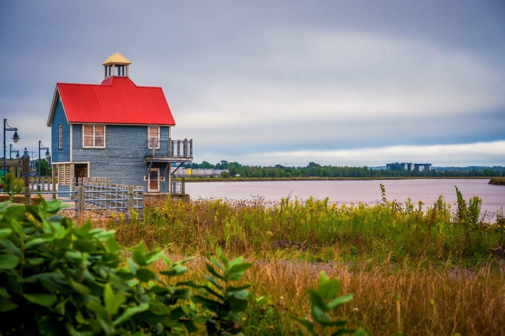 Petitcodiac River met gebouw met rood dak en dramatische lucht