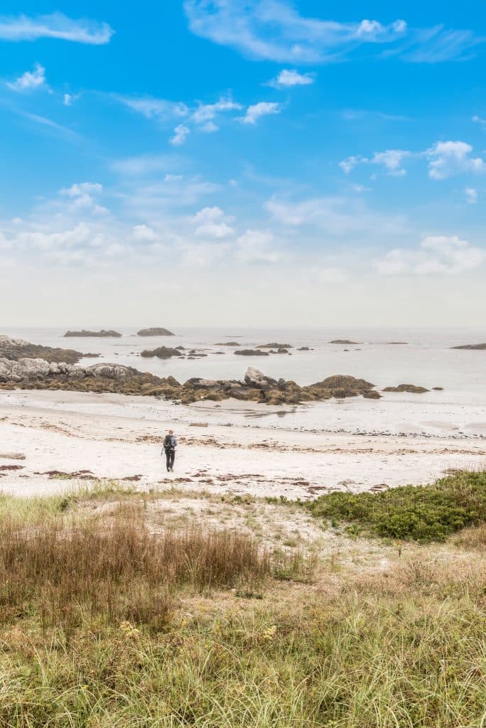Wandelaar op het strand van Kejimkujik National Park met rotsen in de zee