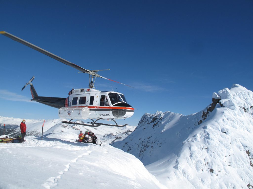 Helikopter zweeft boven besneeuwd berglandschap