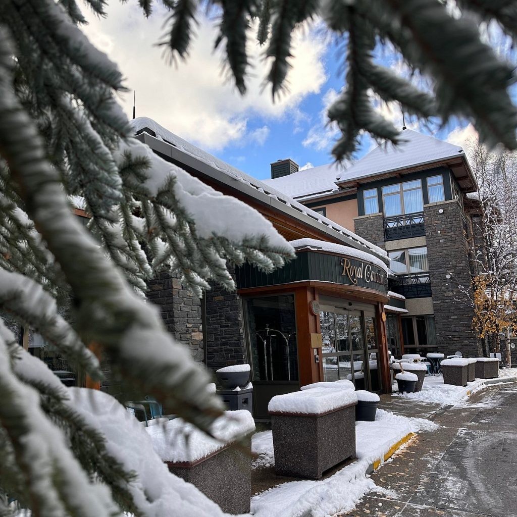 Ingang van Royal Canadian Lodge in Banff met sneeuw en bomen