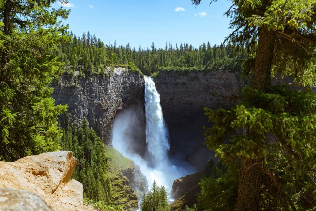 Helmcken Falls in Wells Gray Provincial Park, een hoge waterval die van een steile rotswand in een bosrijke vallei stort.