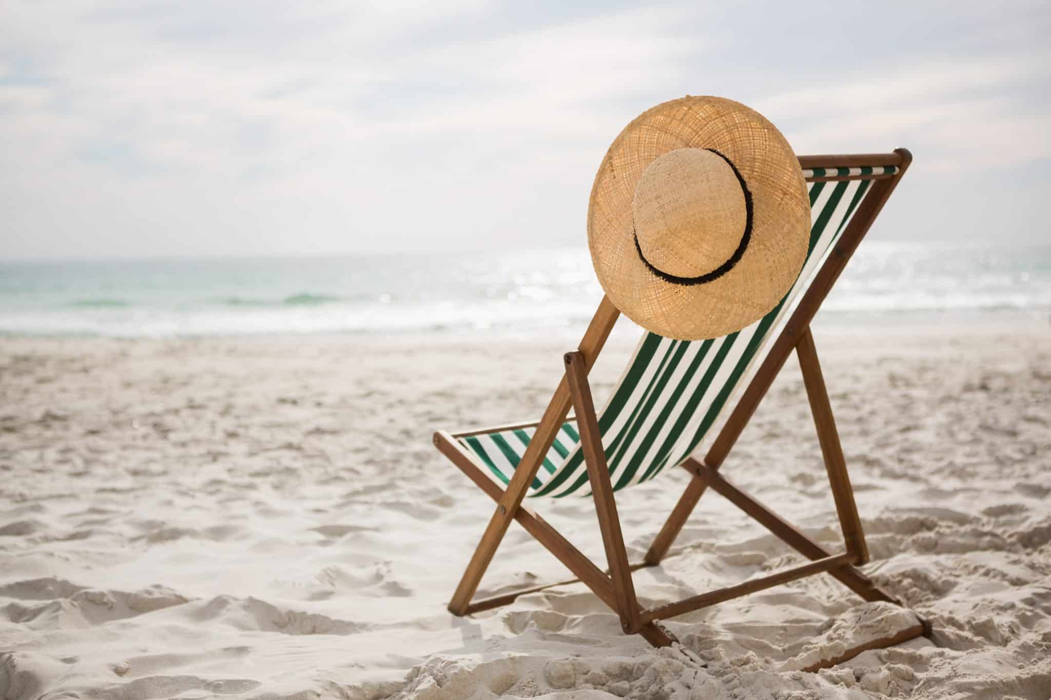 Lege strandstoel met hoed op strand symbool voor geannuleerde vakantie