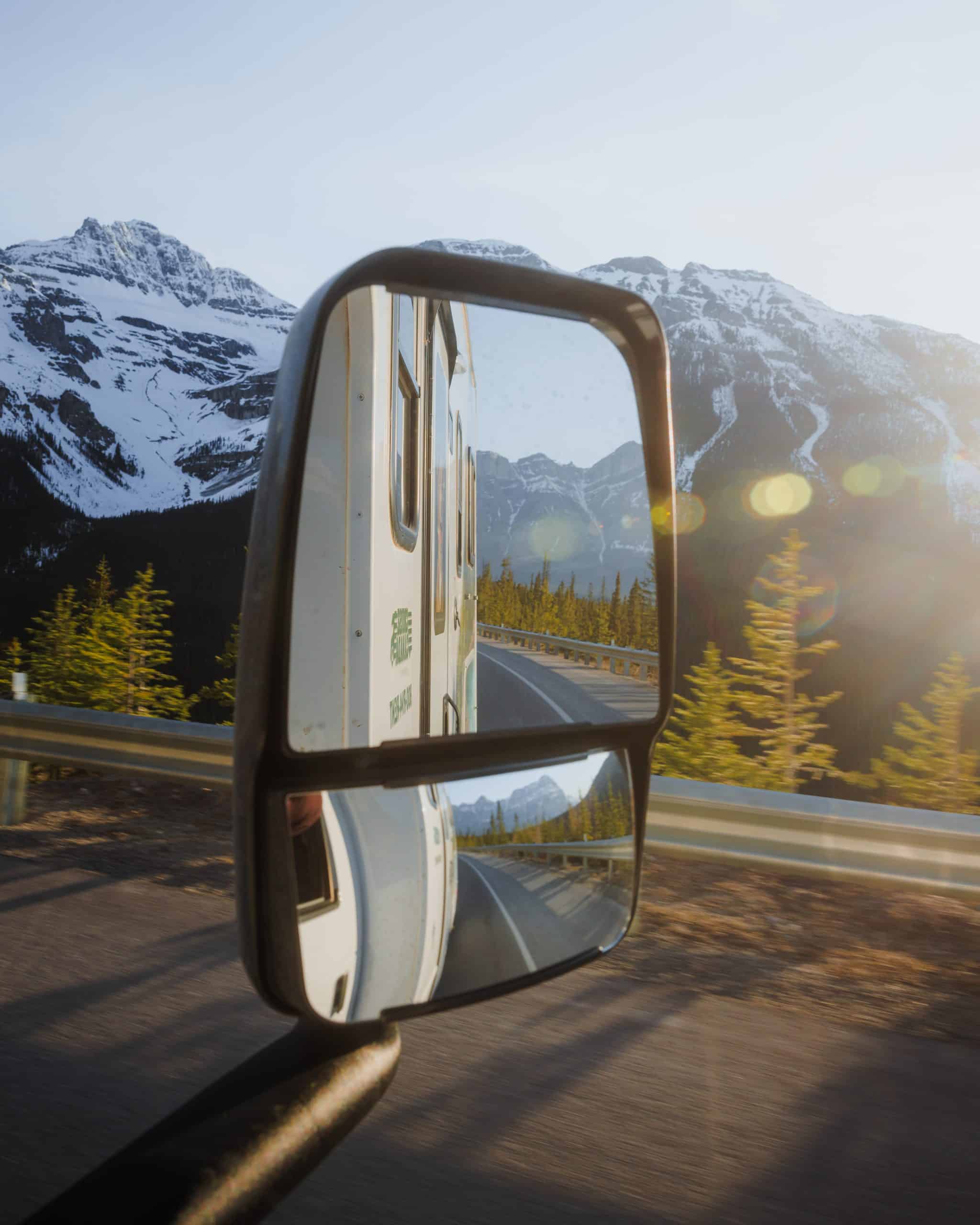 Camper spiegelbeeld op bergweg in Canada met besneeuwde bergen