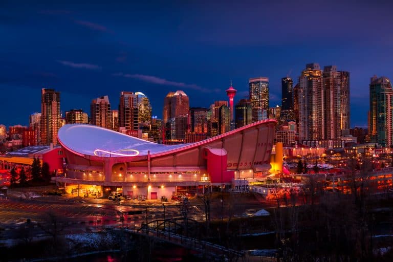Scotiabank Saddledome en skyline van Calgary bij avond