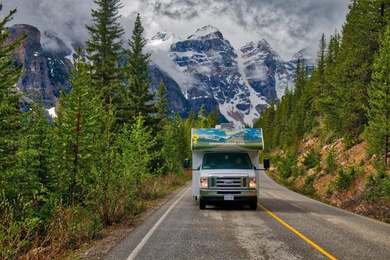 Camper op weg bij Moraine Lake met besneeuwde bergen Alberta