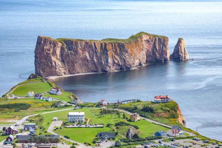 Atlantisch Canada QC Perce Rocher Perce met huizen en groene heuvels