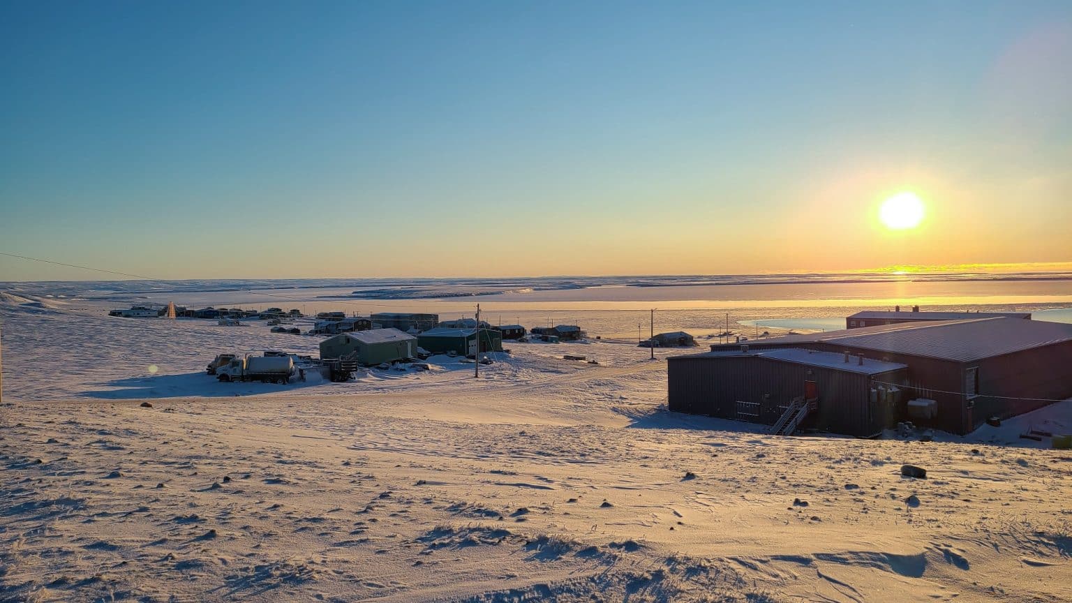 Yukon Noord Canada NT Sachs Harbour dorp aan de kust bij laagstaande zon