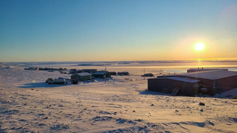 Yukon Noord Canada NT Sachs Harbour dorp aan de kust bij laagstaande zon