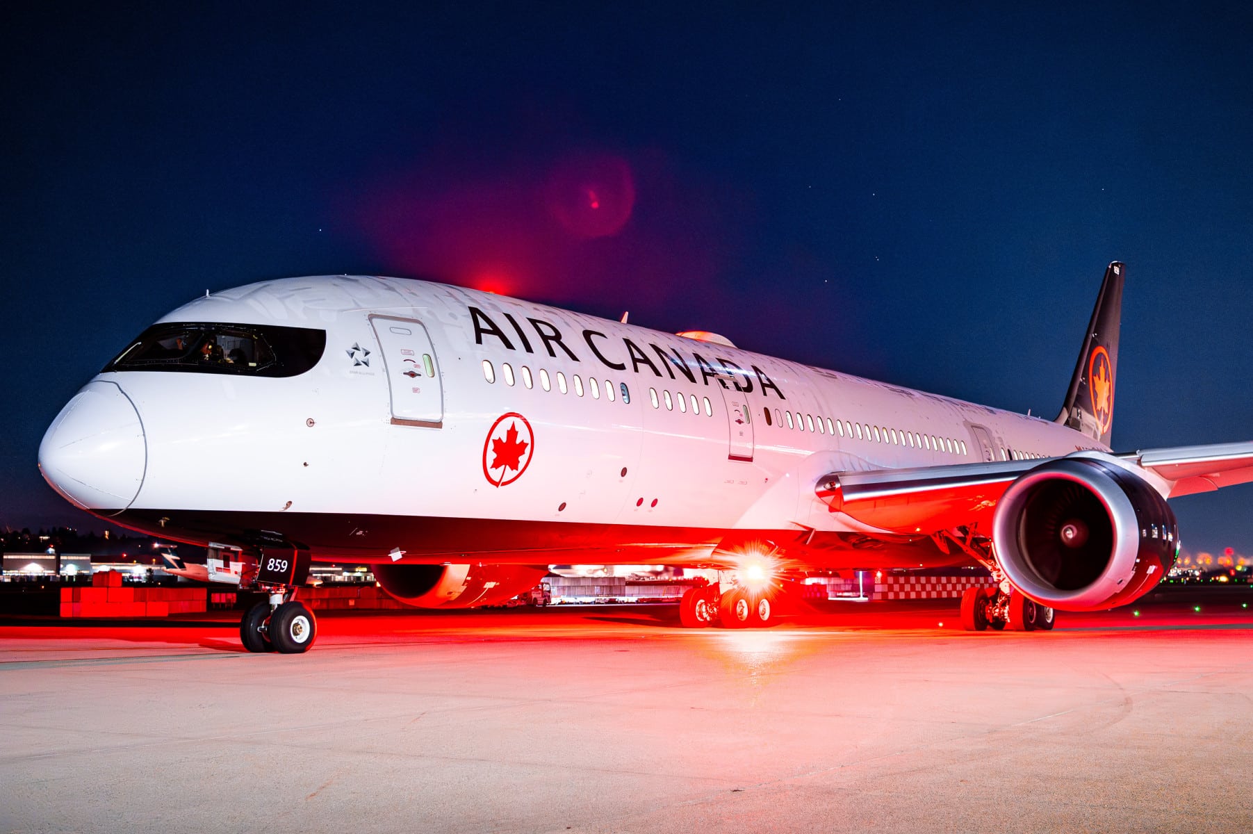 Air Canada Boeing 787 Dreamliner op luchthaven bij nacht met verlichting