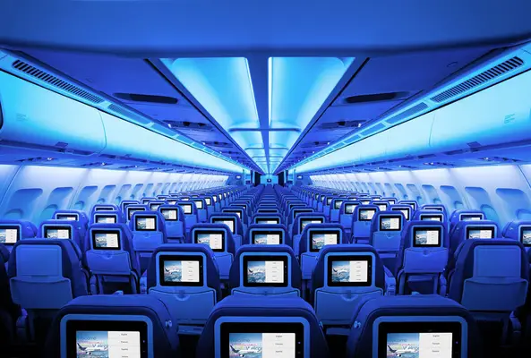 Air Transat vliegtuig cabine economy class met stoelen en entertainment schermen