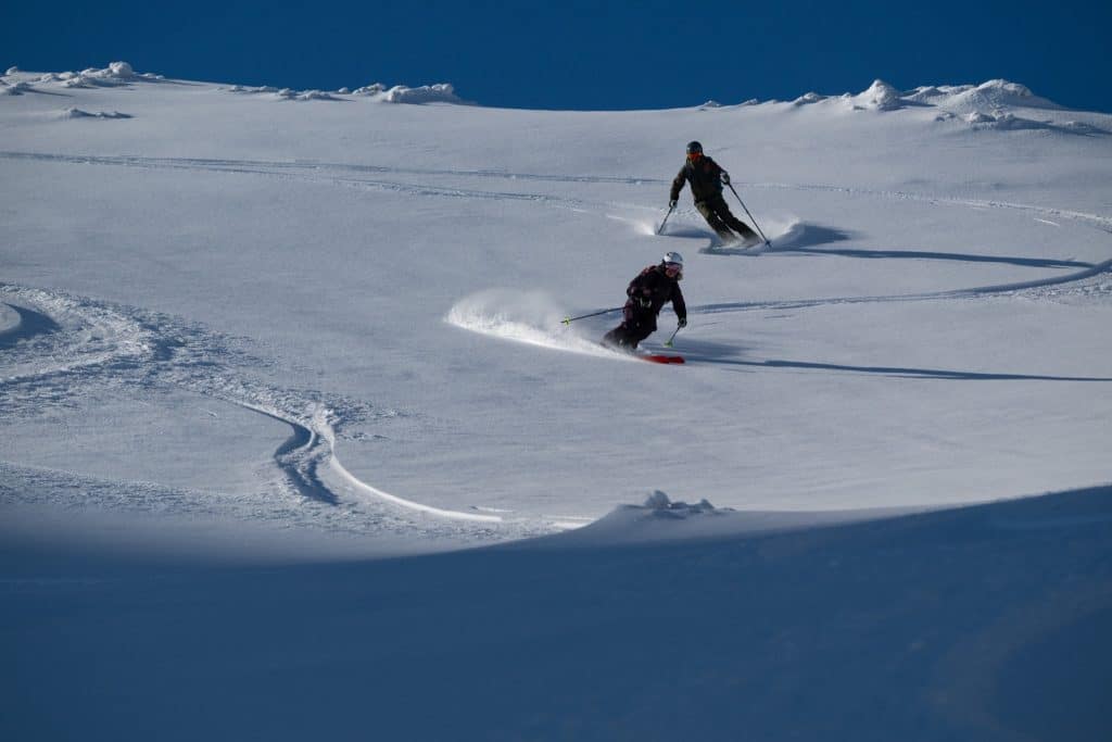 Skiërs in diepe poedersneeuw in Banff National Park in Alberta, een van de mooiste wintergebieden van Canada.