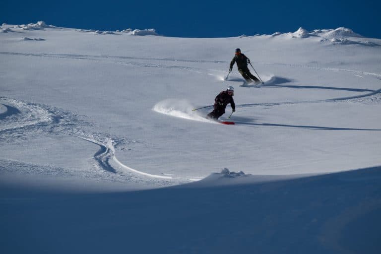 Skiërs in diepe poedersneeuw in Banff National Park in Alberta, een van de mooiste wintergebieden van Canada.
