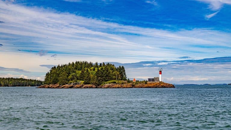 Klein eiland met vuurtoren bij St. Andrews-by-the-Sea in zee