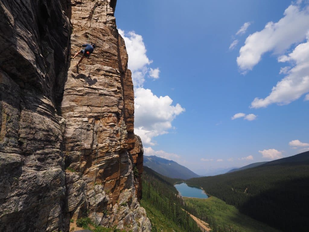 West Canada AB Jasper National Park rotklimmer op klimwand met bergmeer