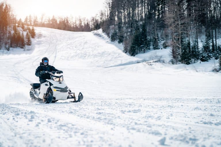 West Canada BC Whistler sneeuwscooter op besneeuwde helling bij bos