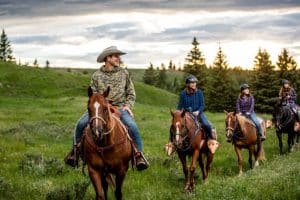 Historic Reesor Ranch met ruiters te paard in het groene landschap van Cypress Hills.