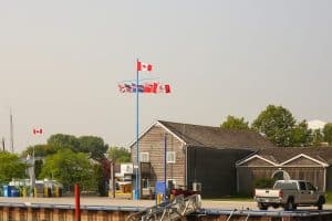Gimli Harbour met houten havengebouw, Canadese vlaggen en kade.