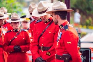 Regina met RCMP-agenten in rood uniform bij de RCMP Academy Depot Division.
