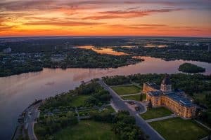 Regina met Saskatchewan Legislative Building en Wascana Lake tijdens zonsondergang.